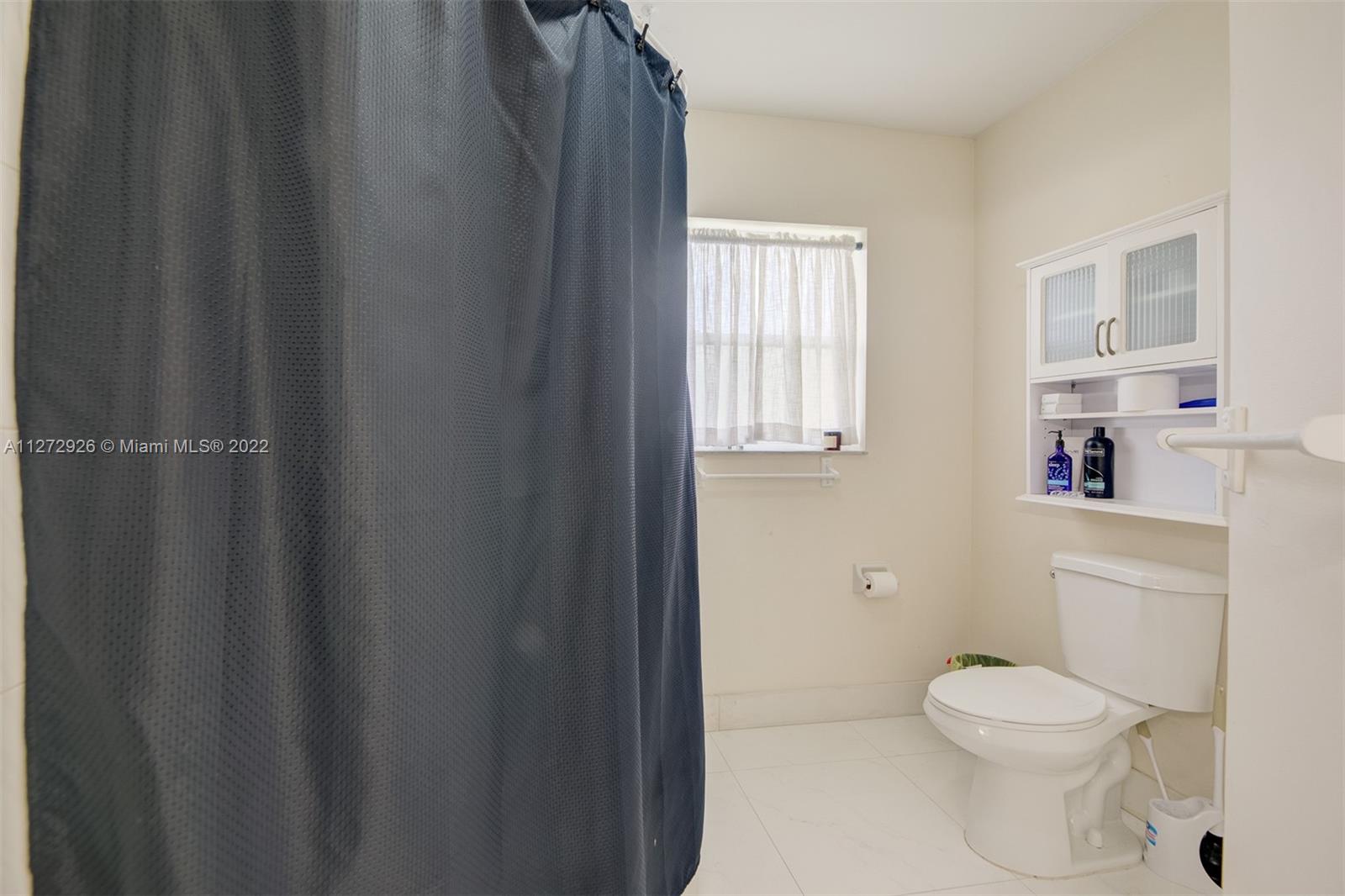 14480 Southwest 112th Street Miami, FL 33186 - Photo 17 of 37 a bathroom with a toilet and a shower curtain