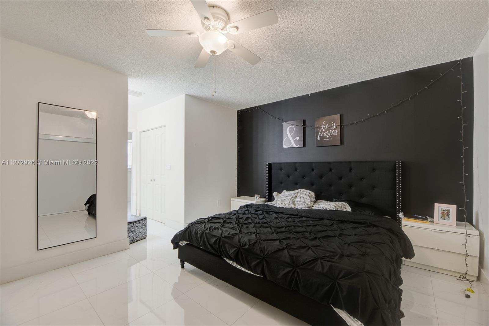 14480 Southwest 112th Street Miami, FL 33186 - Photo 19 of 37 a bedroom with a large bed and a chandelier