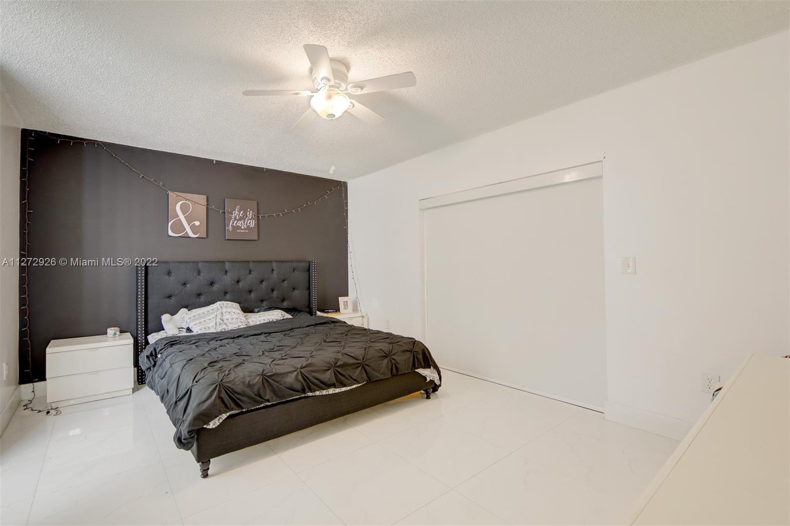 14480 Southwest 112th Street Miami, FL 33186 - Photo 25 of 37 a bedroom with a bed and a chandelier