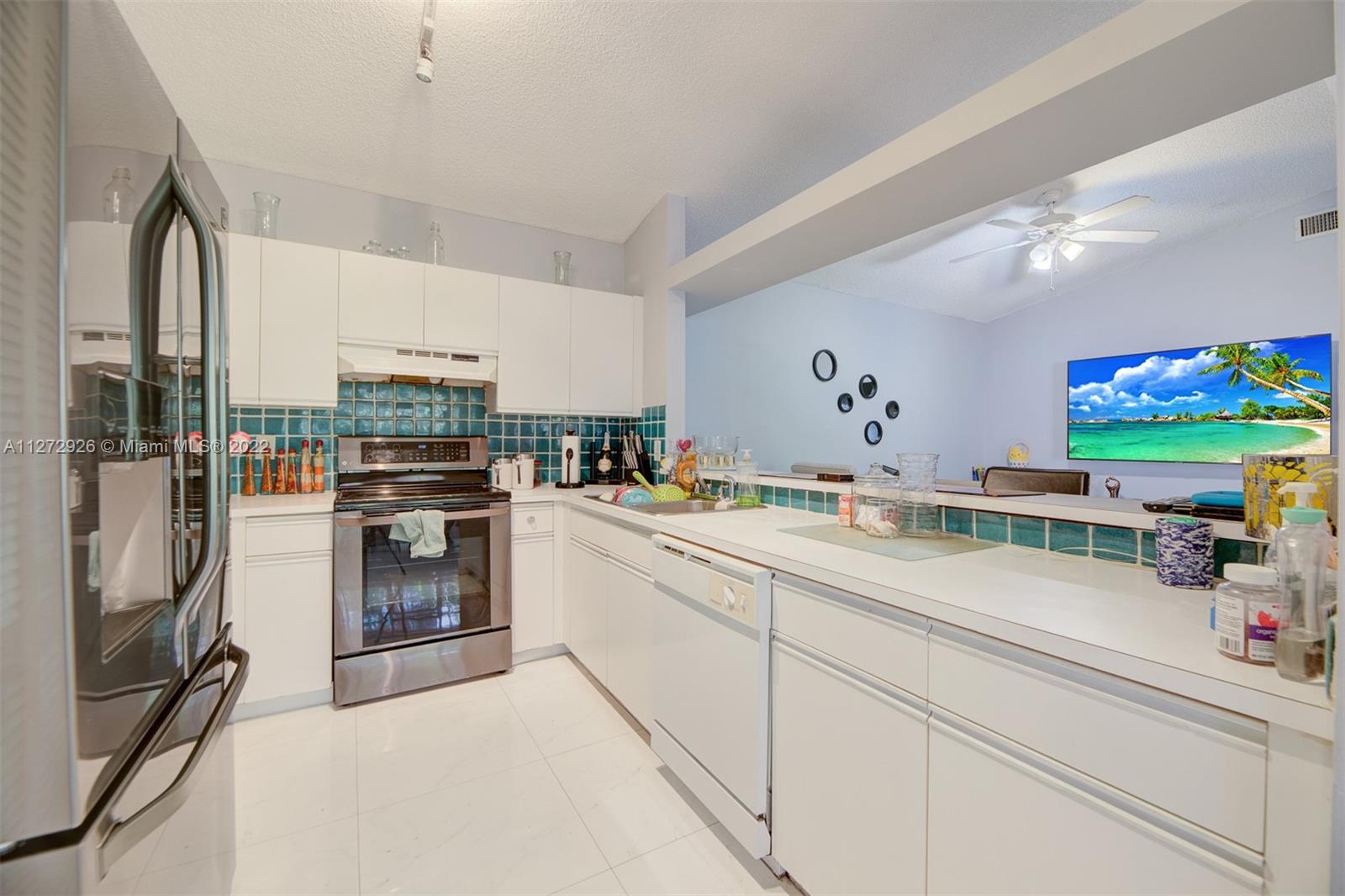 14480 Southwest 112th Street Miami, FL 33186 - Photo 4 of 37 a kitchen with stainless steel appliances granite countertop a sink and cabinets