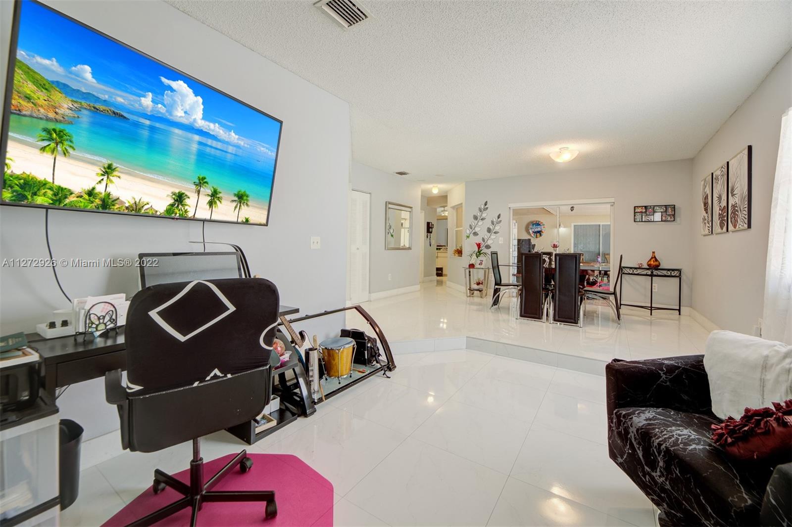 14480 Southwest 112th Street Miami, FL 33186 - Photo 5 of 37 a living room with furniture and a flat screen tv