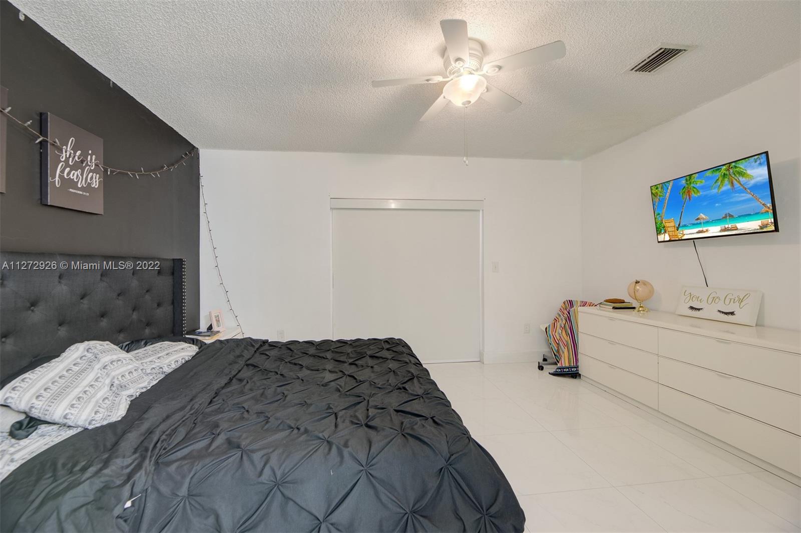 14480 Southwest 112th Street Miami, FL 33186 - Photo 7 of 37 a spacious bedroom with a bed and a chandelier