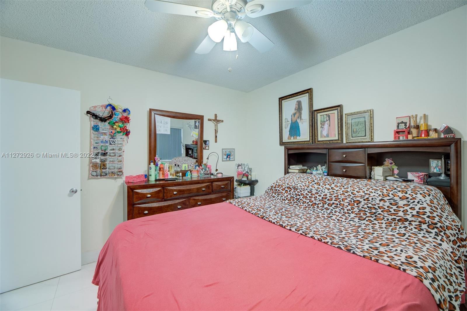 14480 Southwest 112th Street Miami, FL 33186 - Photo 10 of 37 a bedroom with a bed and a chandelier