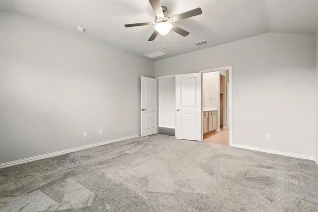 a view of an empty room and a ceiling fan window
