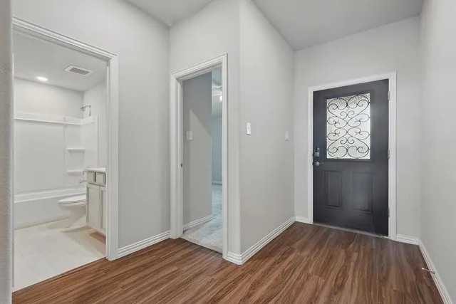wooden floor in an empty room with a bathroom