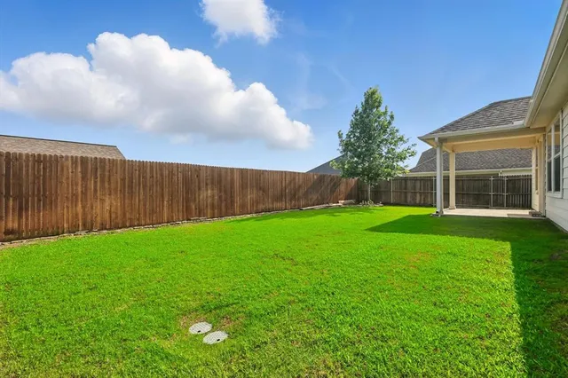 a view of yard with swimming pool and wooden fence