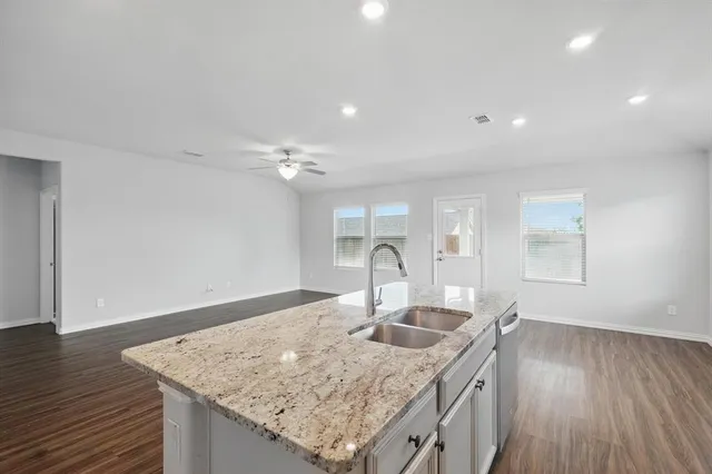 a kitchen with a sink cabinets and wooden floor