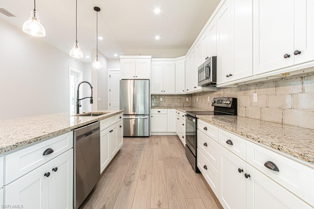 3552 Hibiscus Avenue Naples, FL 34104 - Photo 13 of 34 a large kitchen with granite countertop a white stove top oven sink and cabinets