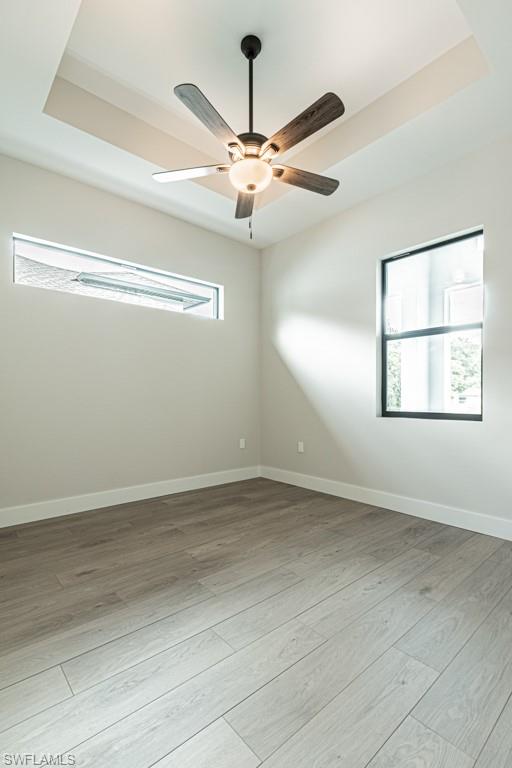 3552 Hibiscus Avenue Naples, FL 34104 - Photo 30 of 34 an empty room with wooden floor chandelier fan and windows