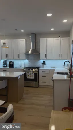 a large kitchen with kitchen island a sink stainless steel appliances and cabinets