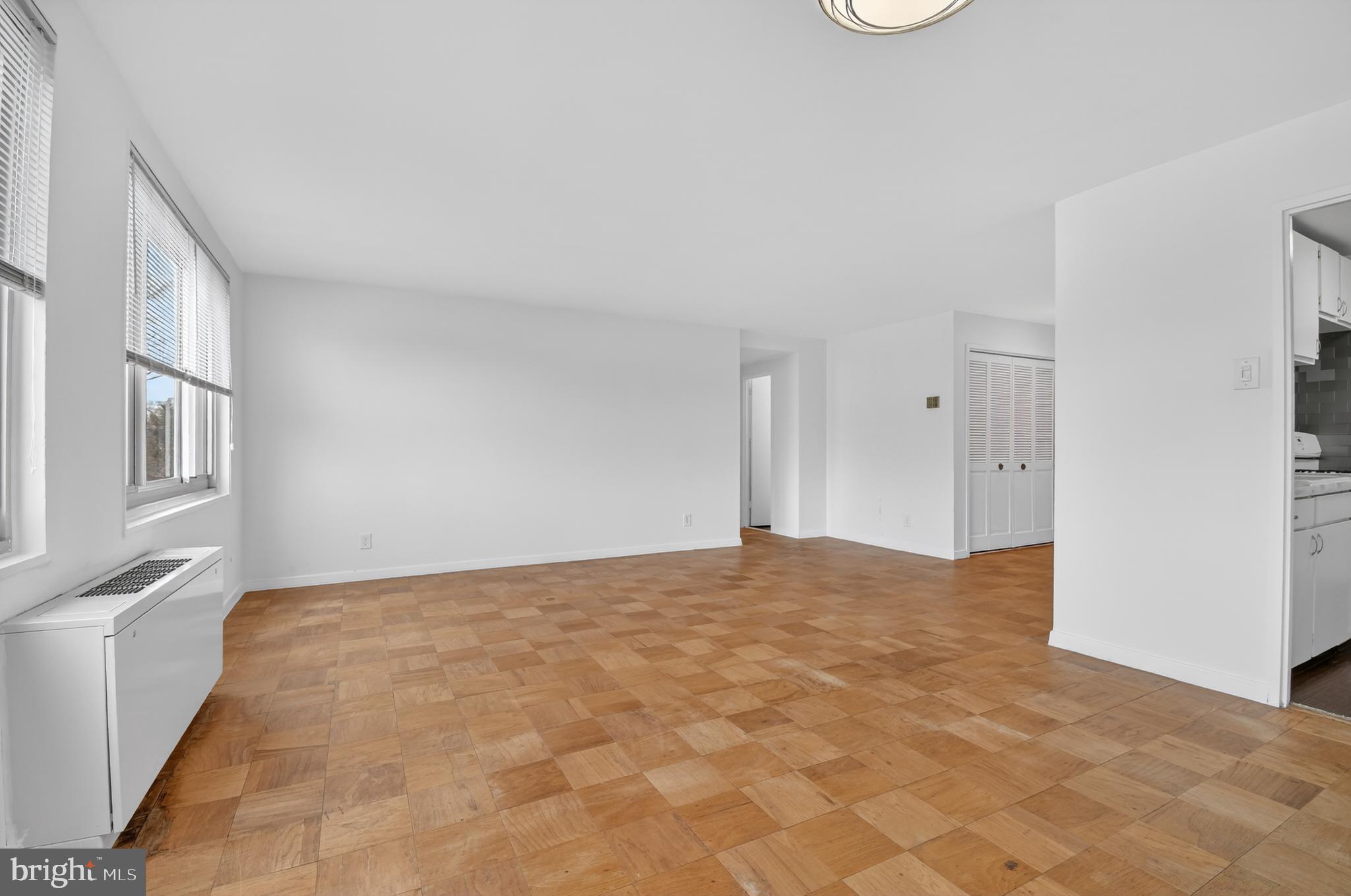 1900 Lyttonsville Road, Unit 718 Silver Spring, MD 20910 - Photo 12 of 35 Living Room with Hardwood Floors & Wall of Windows