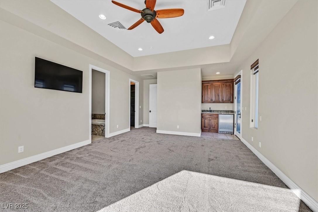 5790 Aspen Falls Circle Las Vegas, NV 89149 - Photo 25 of 61 Unfurnished living room with light carpet, a ceiling fan, recessed lighting, and bar