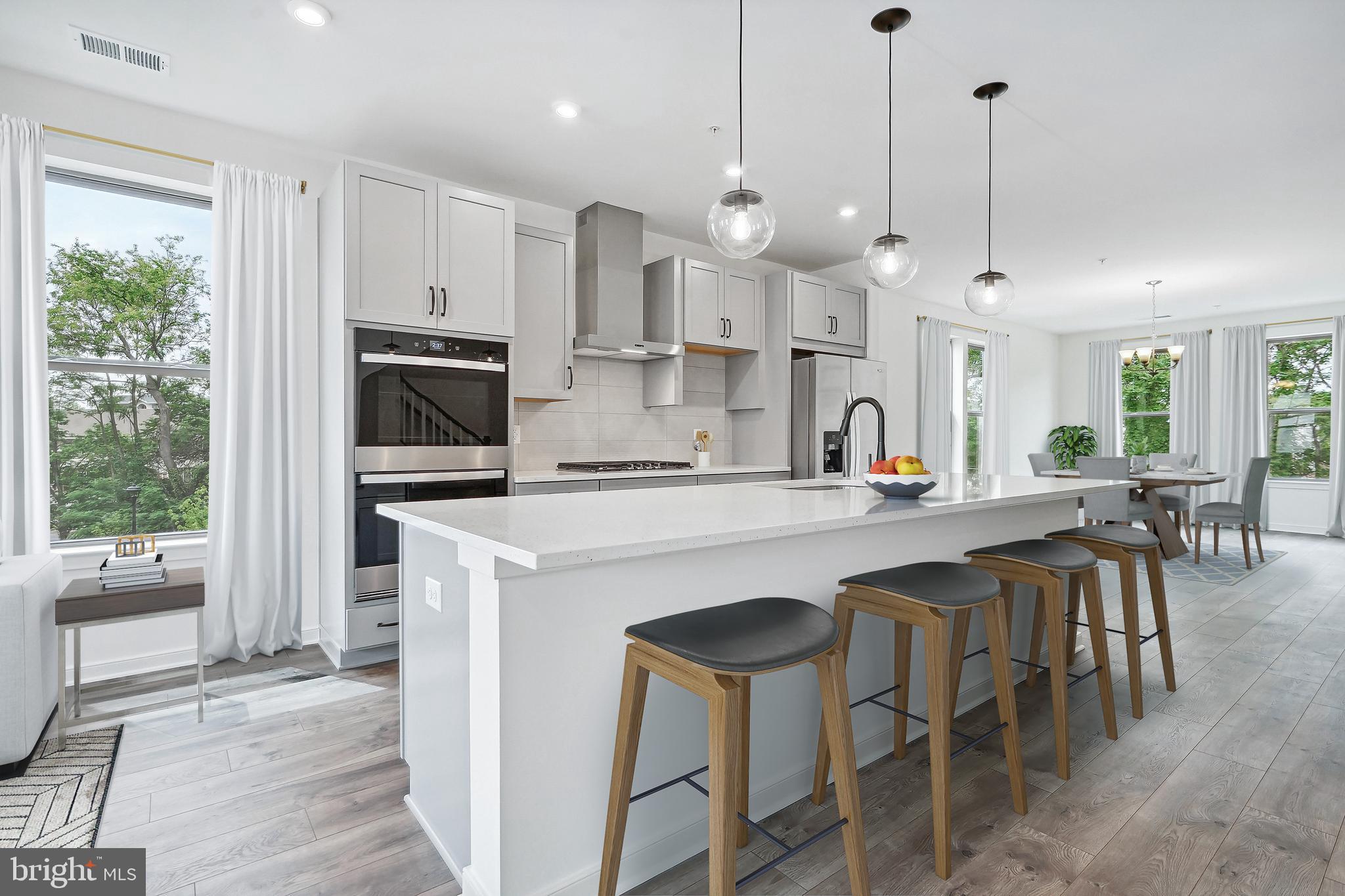 a kitchen with stainless steel appliances kitchen island a large island in the center and wooden floors
