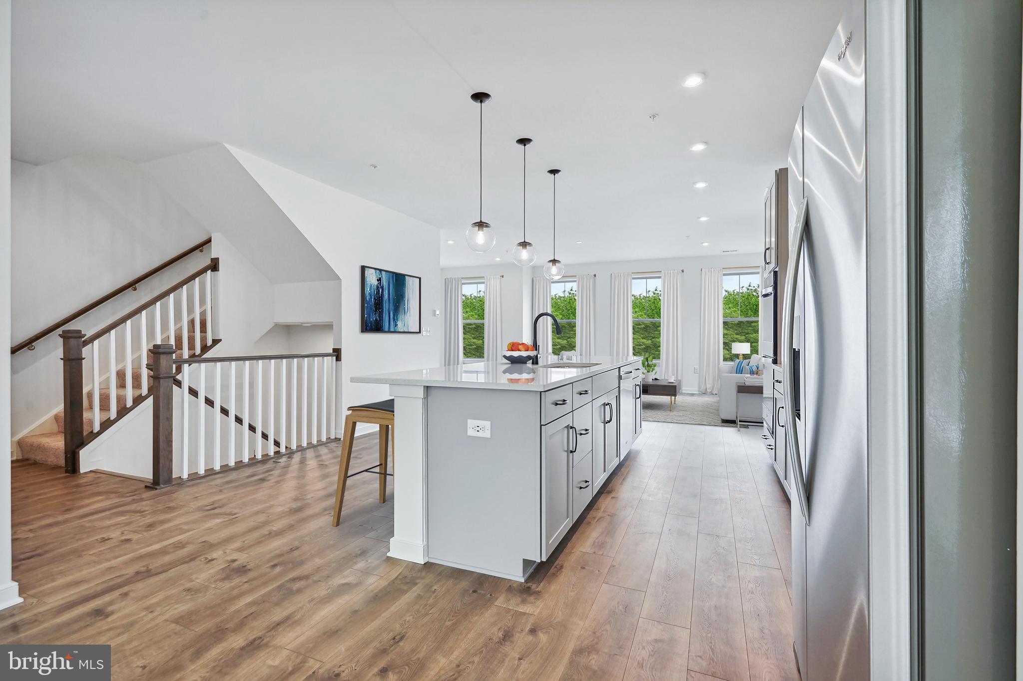 7 Sepia Square, Unit KA Ashburn, VA 20147 - Photo 3 of 19 a large kitchen with stainless steel appliances a large center island wooden floor and a sink