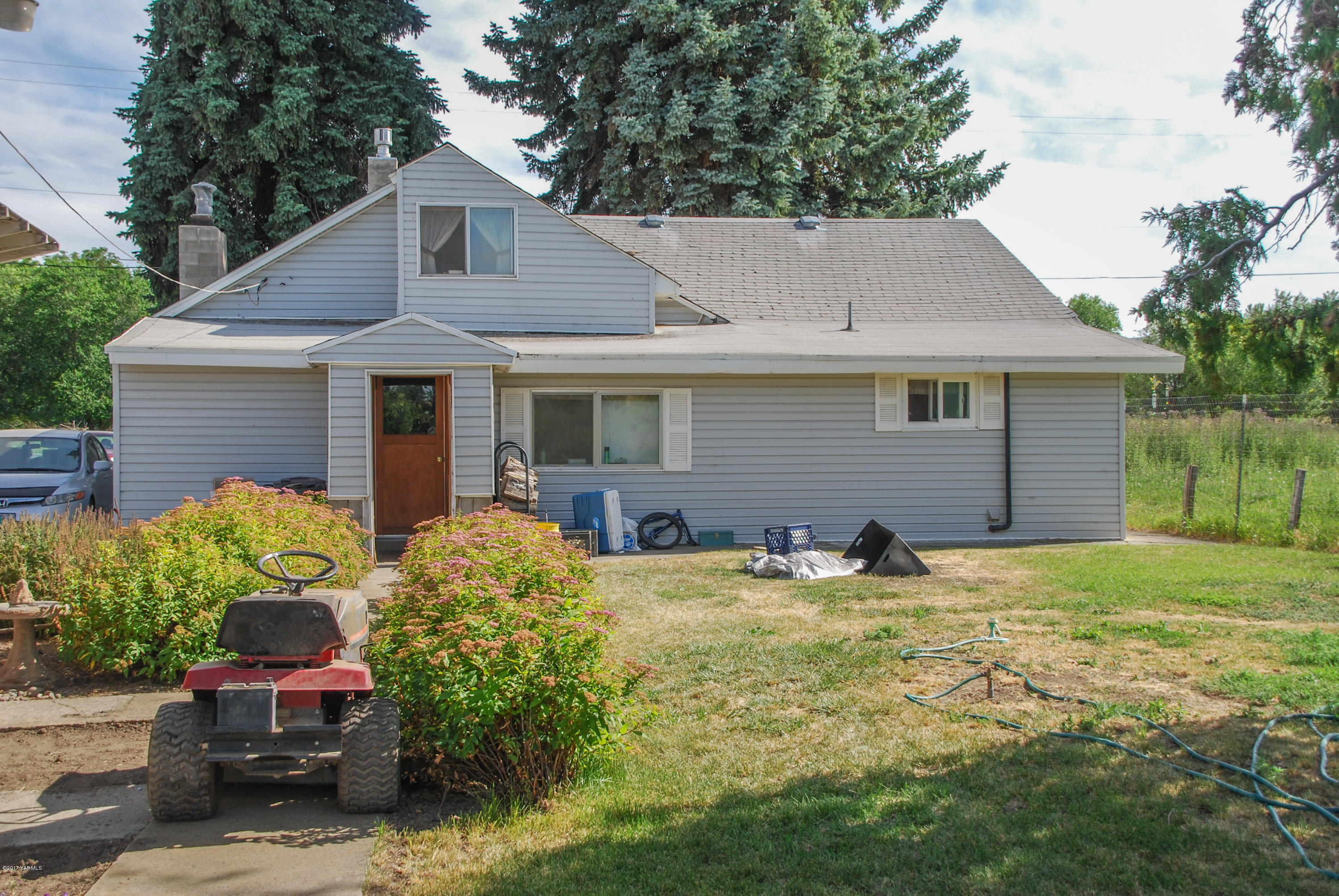 10210 Hughes Road Yakima, WA 98903 - Photo 3 of 21 a backyard of a house with table and chairs and potted plants