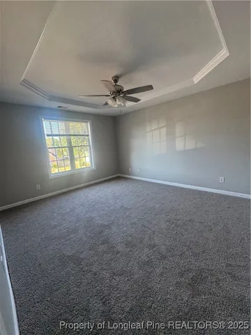 an empty room with windows and ceiling fan