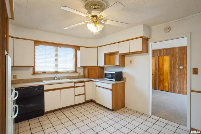 an empty room with a window and a ceiling fan