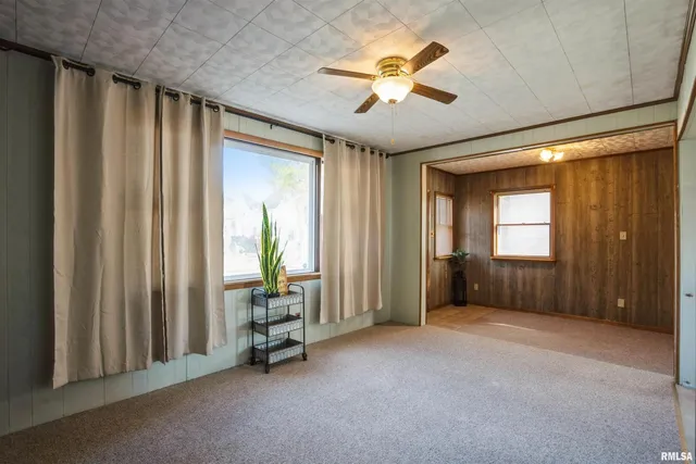 an empty room with windows and closet area