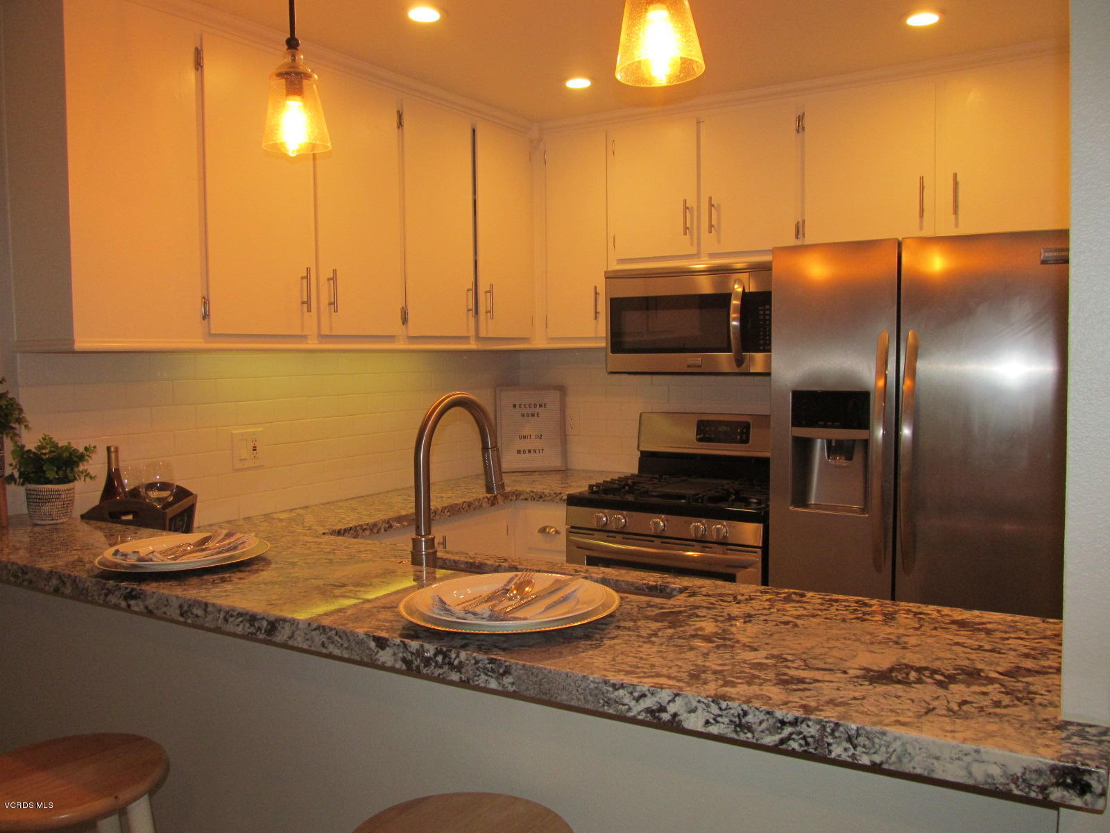 1706 Sinaloa Road, Unit 112 Simi Valley, CA 93065 - Photo 13 of 37 a kitchen with kitchen island granite countertop a stove a sink and a refrigerator