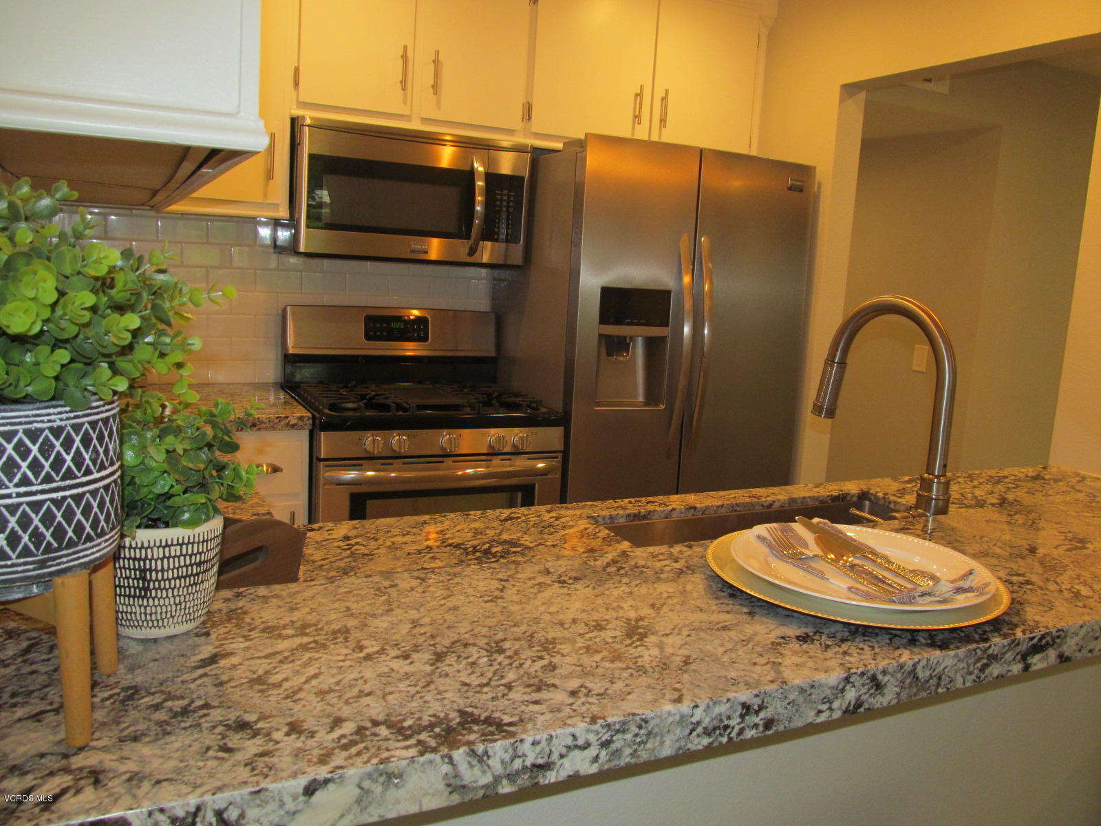 1706 Sinaloa Road, Unit 112 Simi Valley, CA 93065 - Photo 15 of 37 a kitchen with a sink a stove and a microwave