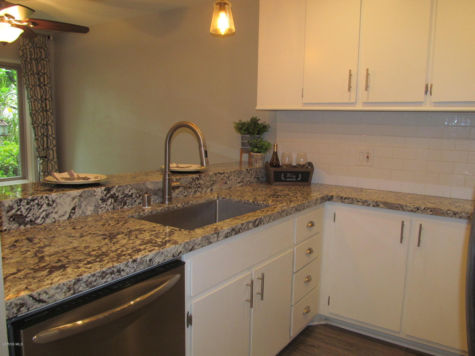 1706 Sinaloa Road, Unit 112 Simi Valley, CA 93065 - Photo 16 of 37 a kitchen with granite countertop white cabinets and a sink