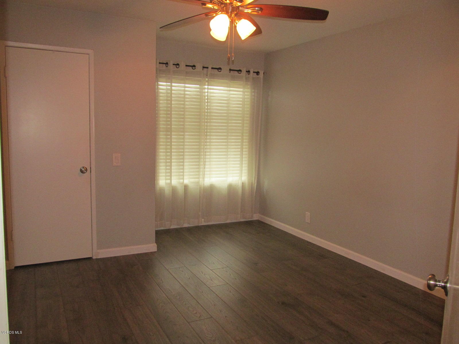 1706 Sinaloa Road, Unit 112 Simi Valley, CA 93065 - Photo 4 of 37 an empty room with wooden floor and windows