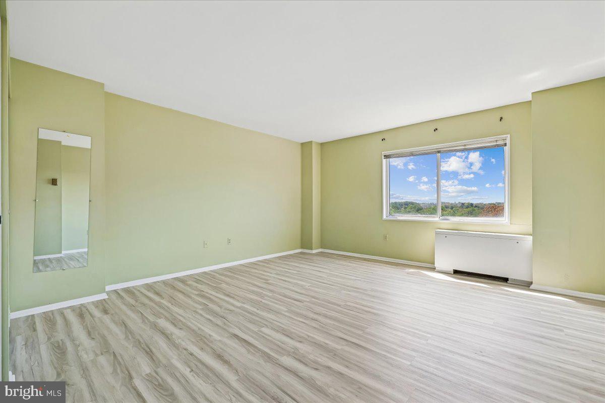 1111 University Boulevard West, Unit 1106A Silver Spring, MD 20902 - Photo 15 of 35 an empty room with wooden floor and windows