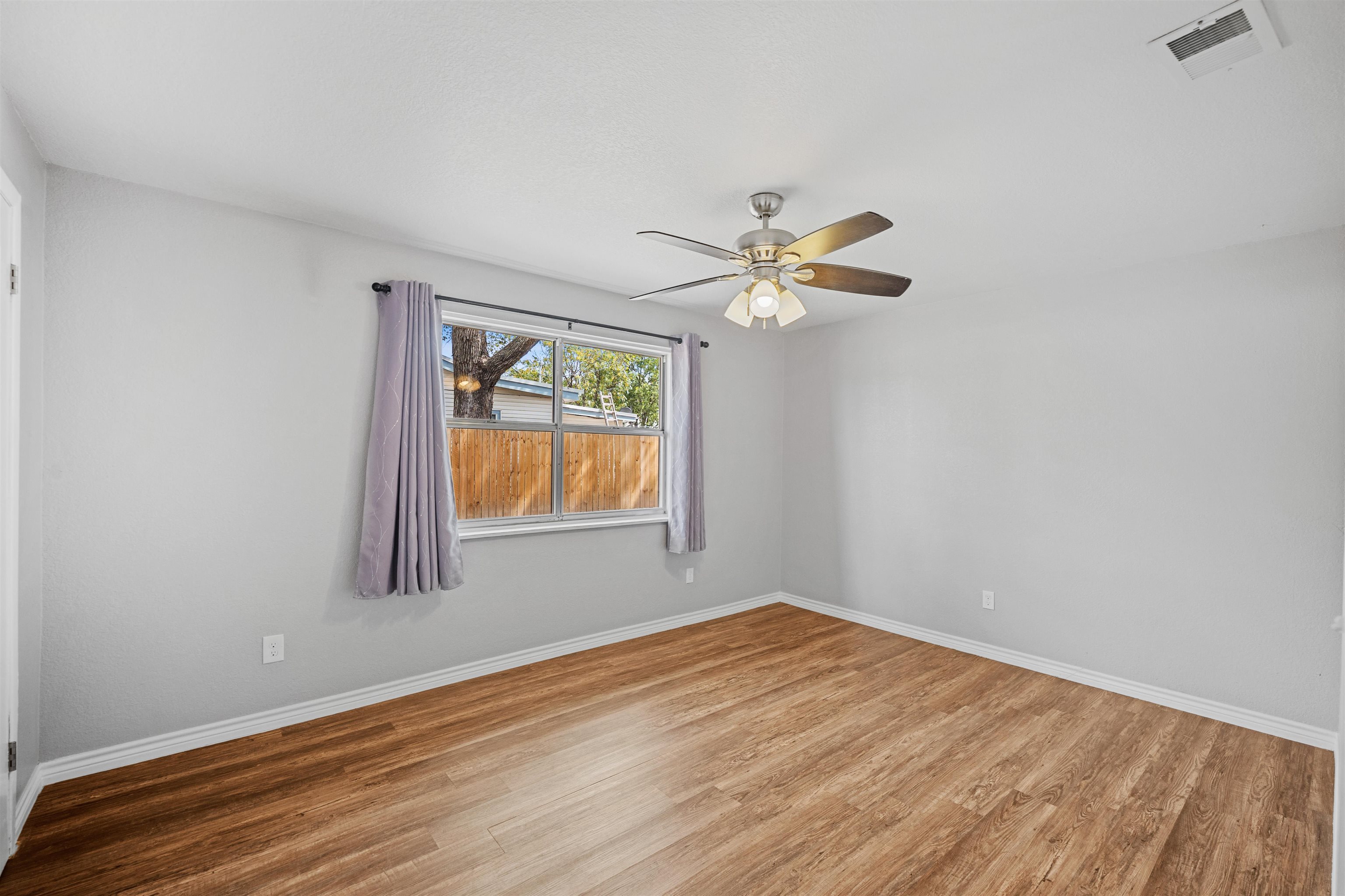 407 Lamon Street Burnet, TX 78611 - Photo 15 of 24 wooden floor in an empty room with a window