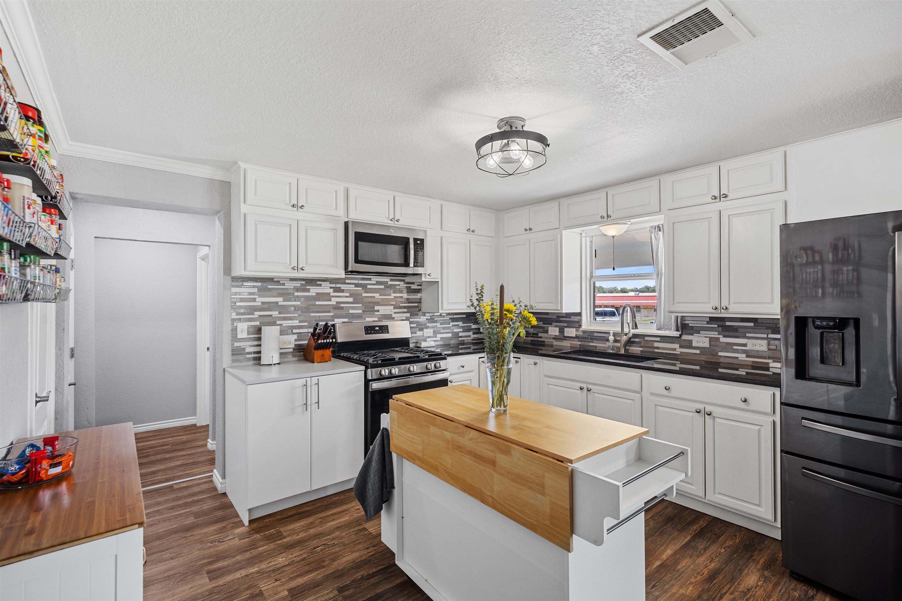 407 Lamon Street Burnet, TX 78611 - Photo 6 of 24 a kitchen with a sink stove top oven and refrigerator