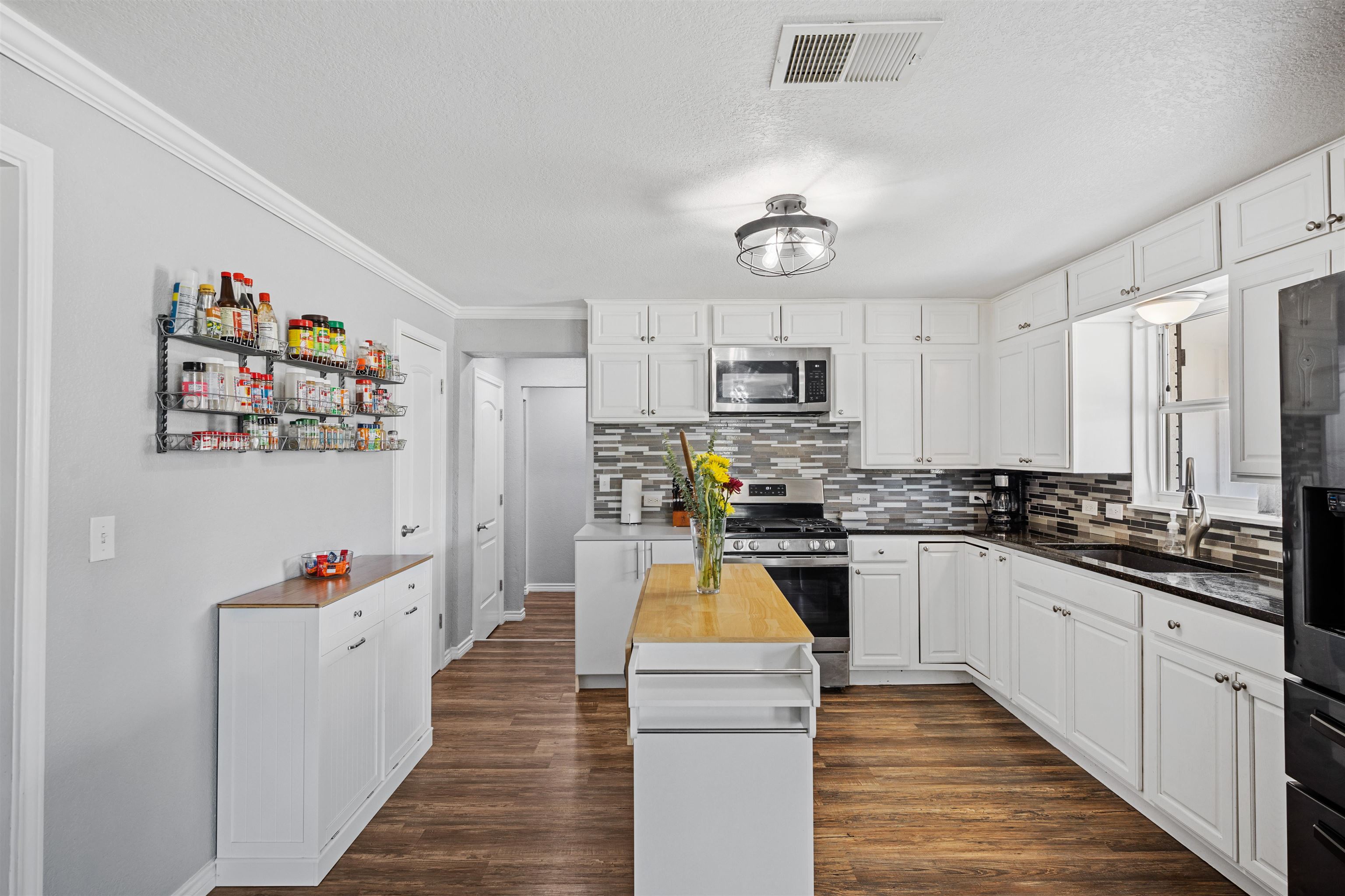 407 Lamon Street Burnet, TX 78611 - Photo 8 of 24 a kitchen with cabinets a sink and appliances