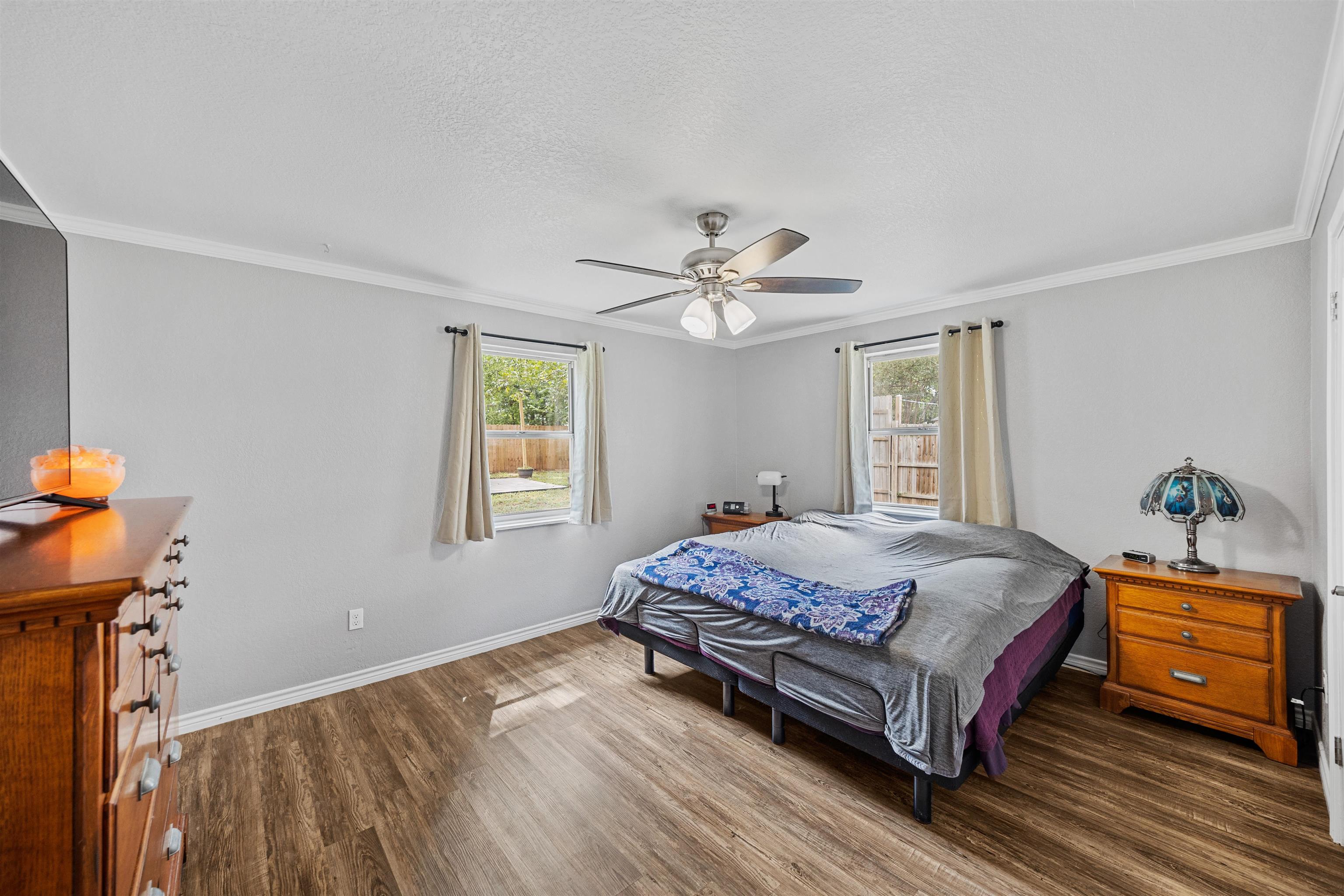 407 Lamon Street Burnet, TX 78611 - Photo 9 of 24 a bedroom with a bed and a chandelier