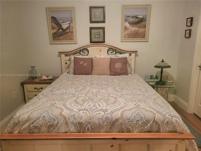 a bedroom with a bed and a painting on the wall
