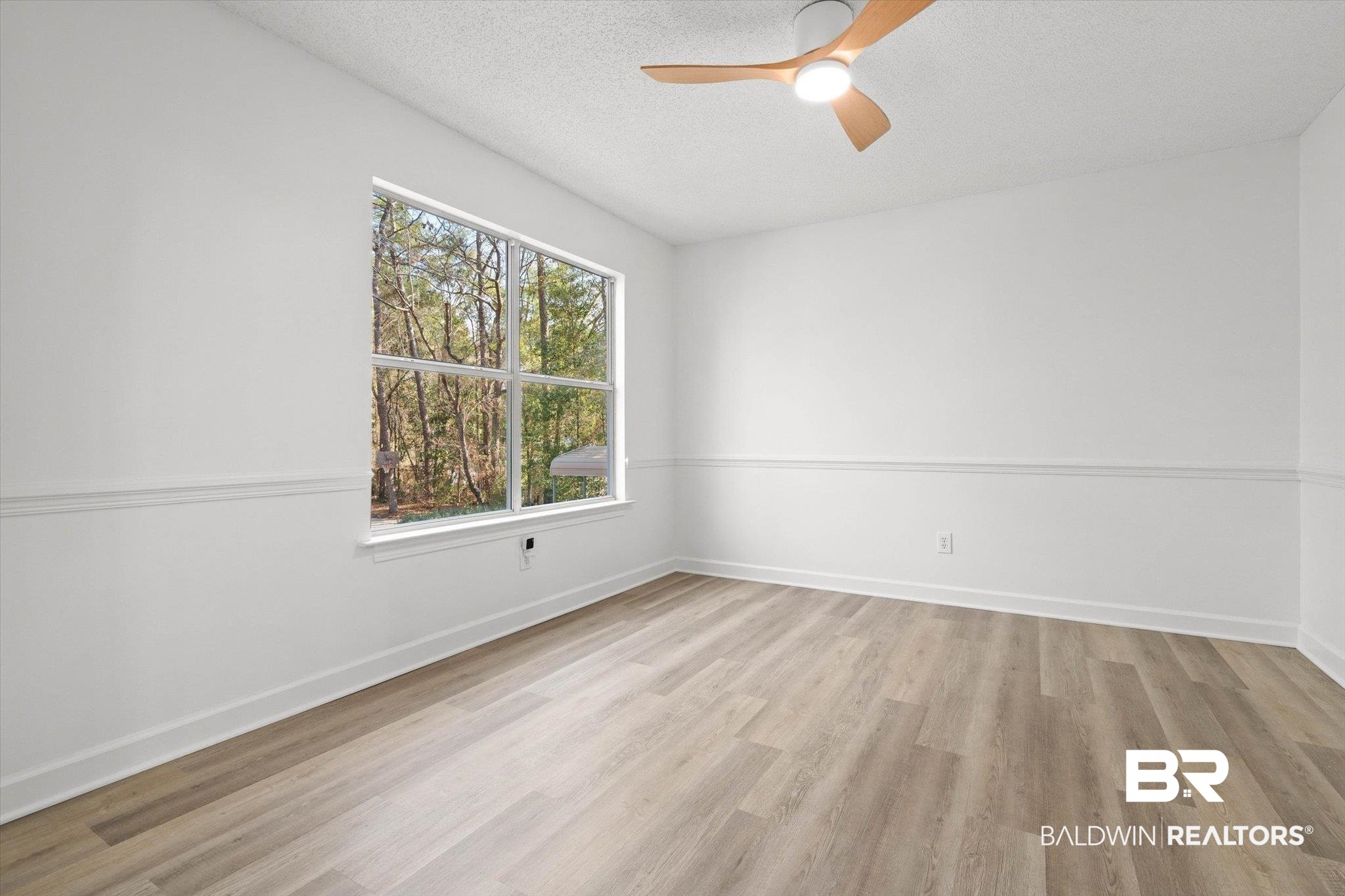 3847 Riviere Du Chien Road Mobile, AL 36693 - Photo 8 of 51 Empty room with a ceiling fan, light wood-style flooring, and a textured ceiling