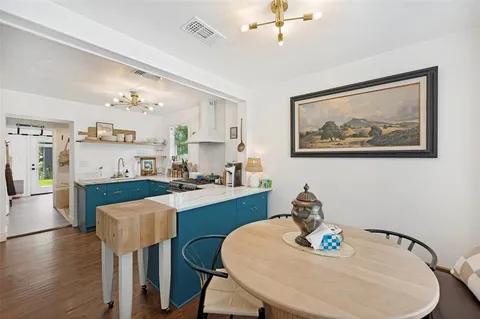 a kitchen with granite countertop white cabinets and refrigerator