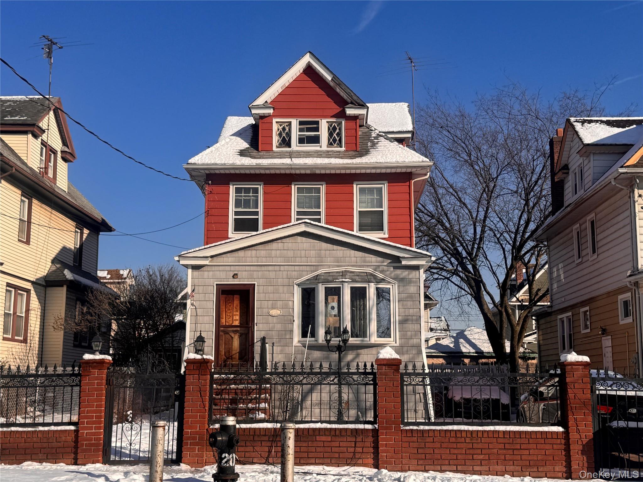 Traditional style home with a gate, a fenced front yard, and a shingled roof