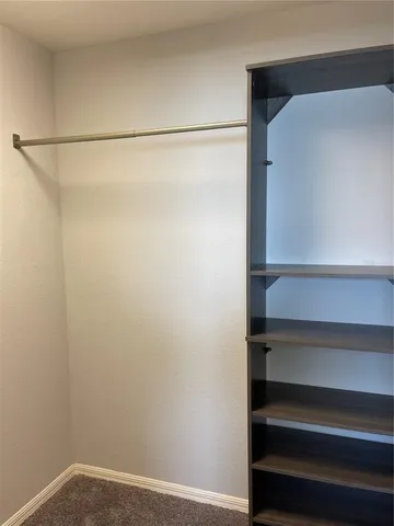 a view of walk in closet with empty racks