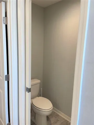 a white toilet sitting next to a shower
