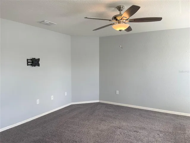a view of an empty room with a ceiling fan