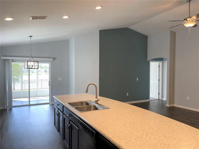 a kitchen with a sink and wooden floor