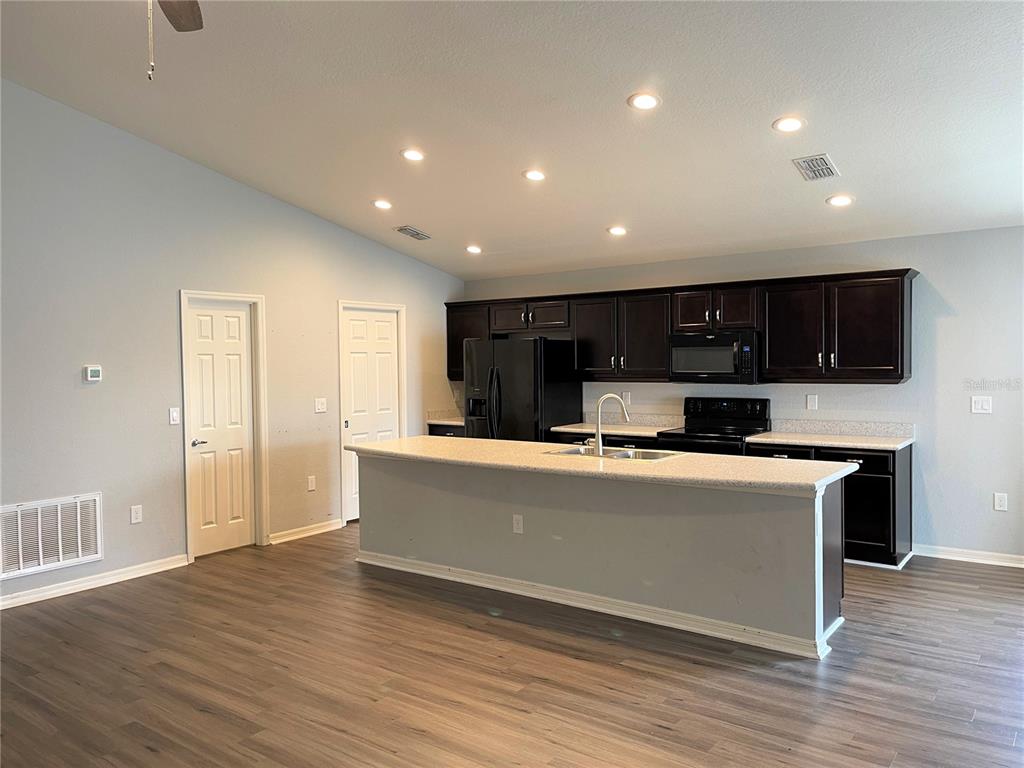 3623 Peregrine Way Lakeland, FL 33811 - Photo 7 of 35 a living room with stainless steel appliances kitchen island granite countertop a stove and a refrigerator with wooden floor