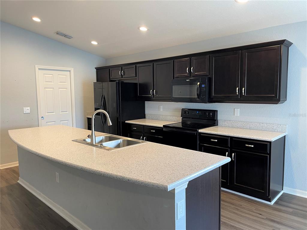 3623 Peregrine Way Lakeland, FL 33811 - Photo 8 of 35 a kitchen with a sink a stove and refrigerator