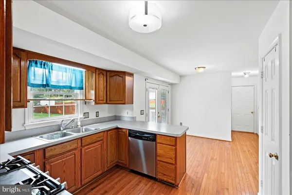 a kitchen with stainless steel appliances granite countertop a sink stove and wooden cabinets