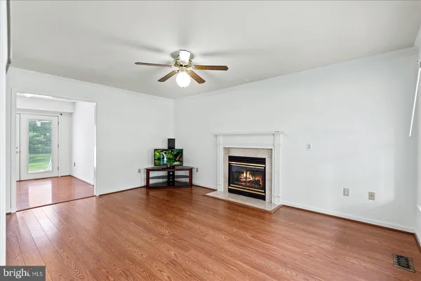 a view of empty room with wooden floor and fireplace