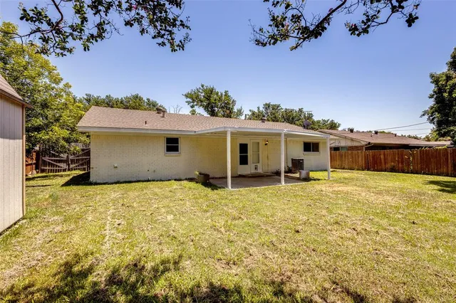 a view of a house with a backyard and a tree