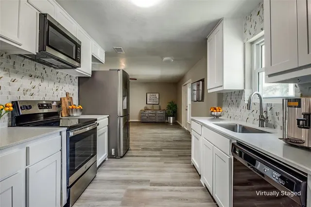 a kitchen with stainless steel appliances a stove sink microwave and cabinets