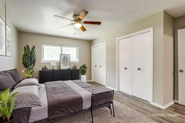 a bedroom with a large bed a chandelier and a window