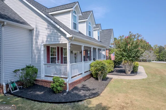 a front view of a house with a yard and potted plants