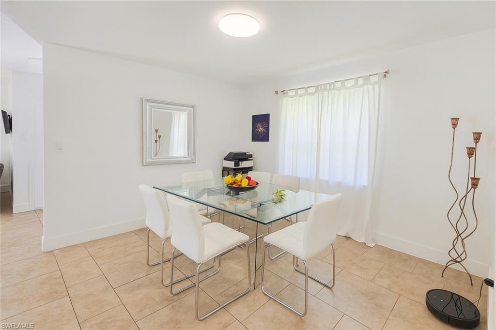 5010 31st Avenue Southwest Naples, FL 34116 - Photo 13 of 33 a dining room with furniture and a potted plant