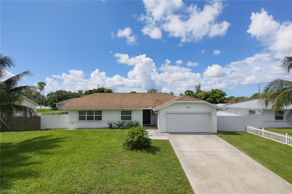 5010 31st Avenue Southwest Naples, FL 34116 - Photo 2 of 33 a front view of house with yard and green space