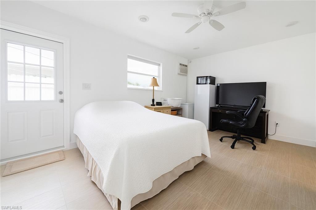5010 31st Avenue Southwest Naples, FL 34116 - Photo 21 of 33 a bedroom with a bed and a chandelier